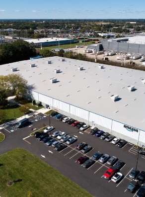 an aerial view of an amazon building with cars parked in front of it