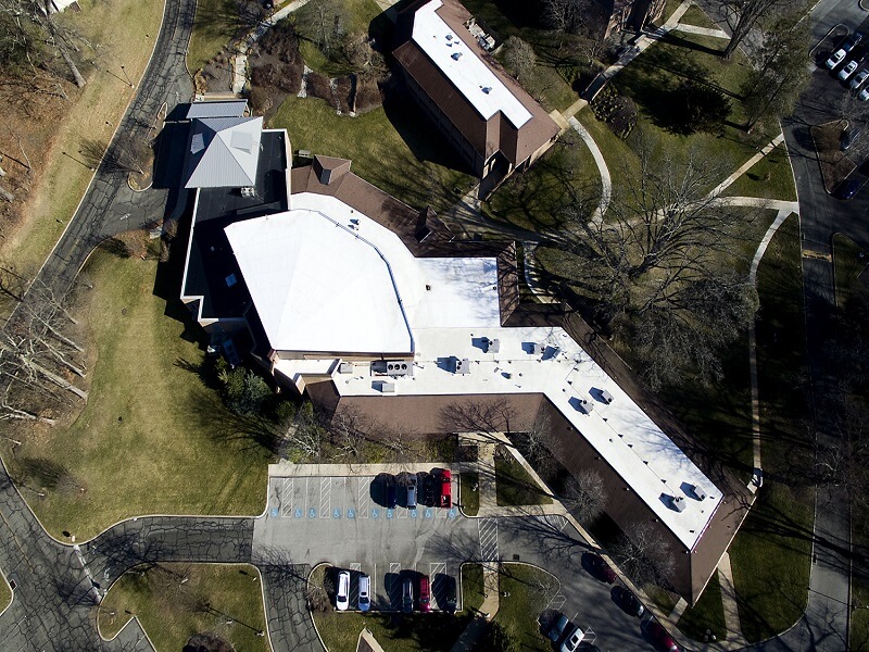 an aerial view of a large building with a white roof