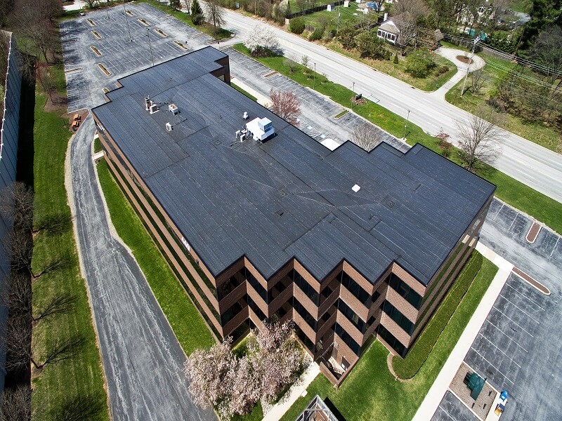 an aerial view of a large building with a black roof
