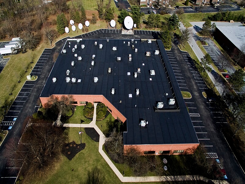 an aerial view of a large building with satellite dishes on the roof