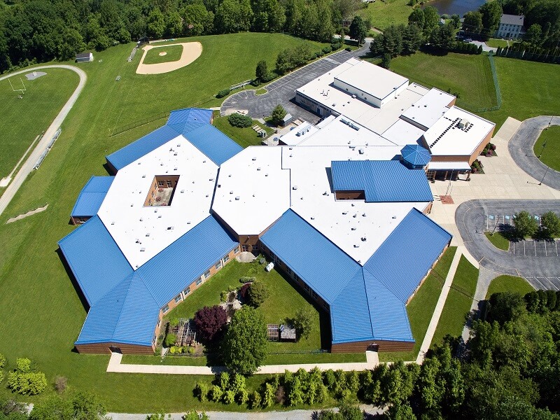 an aerial view of a school with blue roofs