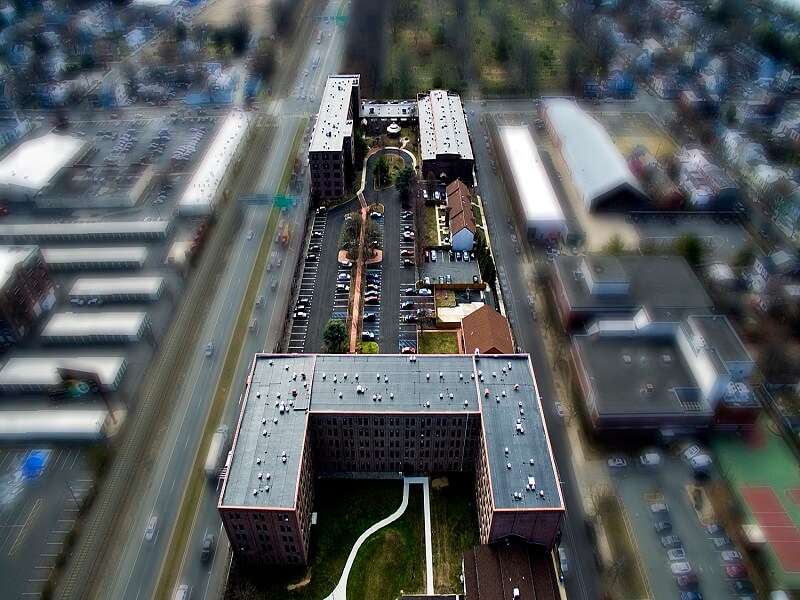an aerial view of a large building with a lot of cars parked around it