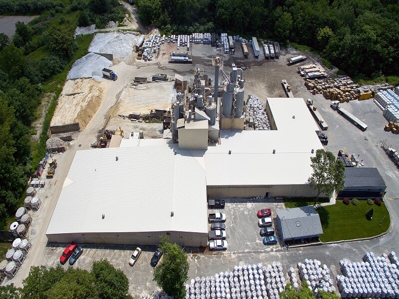 an aerial view of a large building with a white roof surrounded by a job site